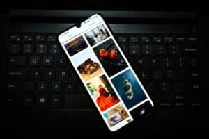 Smartphone displaying social media feed on keyboard representing phone addiction and doomscrolling behavior